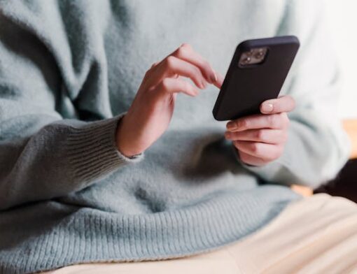 Pessoa sentada com um smartphone nas mãos