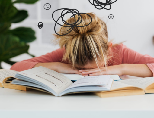 Pessoa debruçada sobre livros abertos em uma mesa, sinal evidente de esgotamento mental relacionado com burnout 
