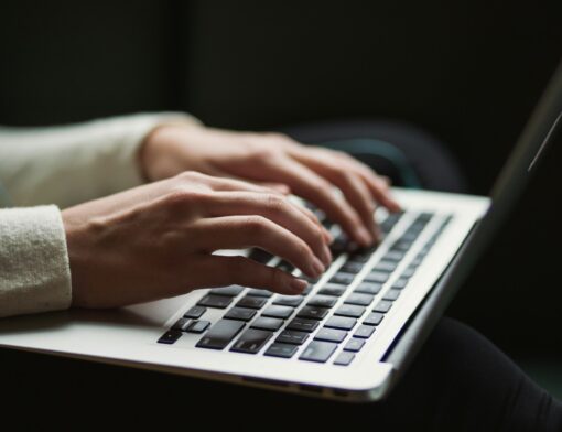 Pessoa com laptop no colo conectando-se com outras pessoas ao redor do mundo. 