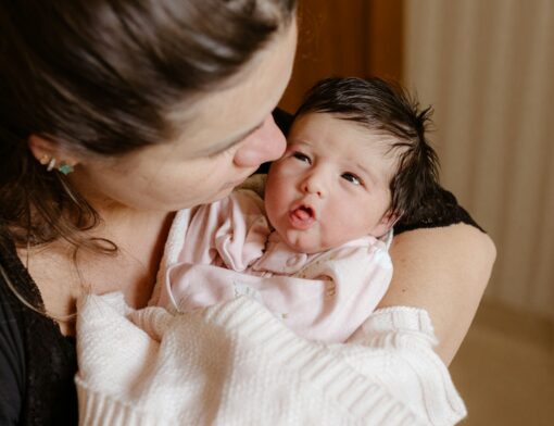 Uma mãe segurando um bebê recém-nascido no colo.
