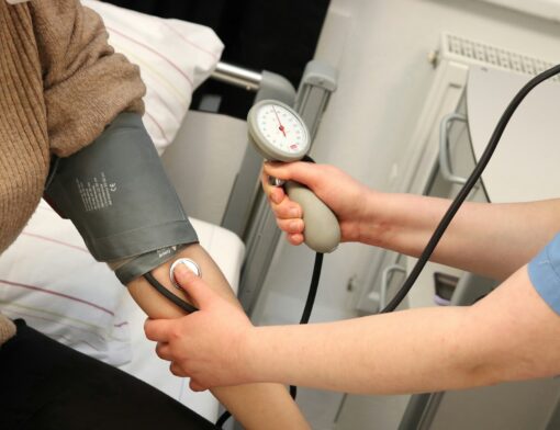 Um profissional de saúde aferindo a pressão de um paciente durante check-up anual