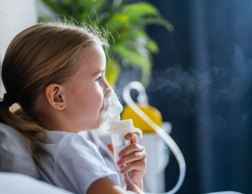 Momento de cuidado: uma menina usando um nebulizador para aliviar a respiração.