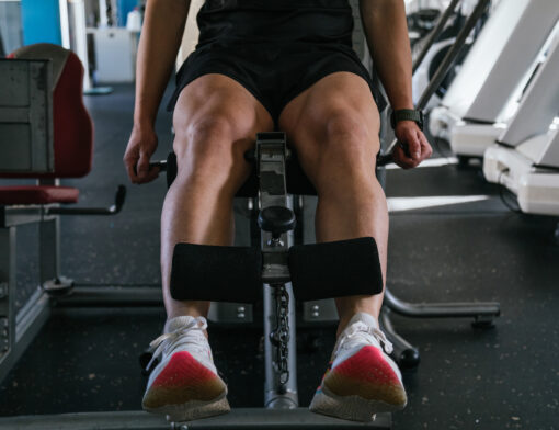 Pessoa de exercitando em uma cadeira extensora